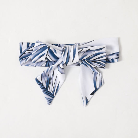 Young boy wearing a white short-sleeve t-shirt with blue tropical leaf print and a black chest pocket. - Image 24