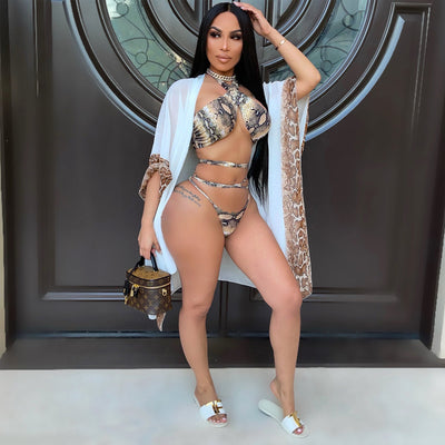Woman in a three-piece snake print bikini with a halter top, wrap-around straps, and a sheer white shawl. - Image 10