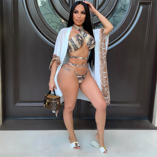 Woman in a three-piece snake print bikini with a halter top, wrap-around straps, and a sheer white shawl. - Image 10