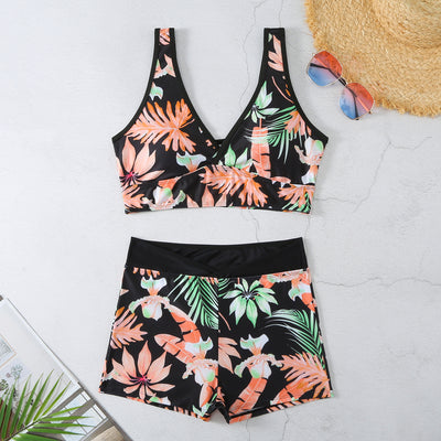 Two-piece swimsuit with a black background and vibrant pink and purple tropical floral print. Features a V-neck crop top and high-waisted boxer shorts. - Image 10