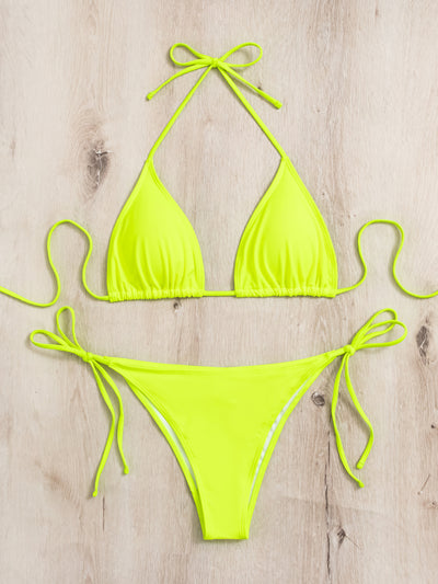 Neon yellow halter bikini with triangle top and tie-side bottoms, displayed on a light wood surface. - Image 34