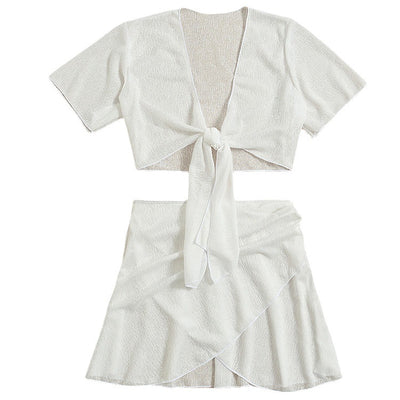 White two-piece swimwear set with a tie-front crop top and a high-waisted skirt with an asymmetrical ruffled hem. - Image 5