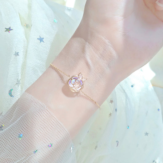 Gold-tone necklace with an iridescent camellia flower pendant and small clear stones on a delicate chain. - Image 4