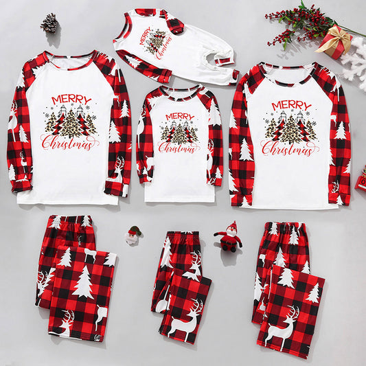 Matching family Christmas pajamas in red and black plaid with "Merry Christmas" text, tree, and reindeer prints.