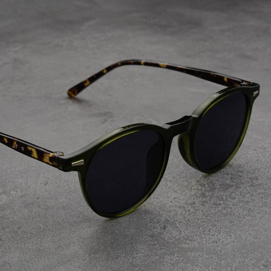 Fashionable round-frame sunglasses with transparent gray frames and dark gray lenses on a gray surface. - Image 13