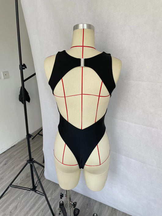 Women's black one-piece swimsuit with a high neck, chest cut-out, and rhinestone embellishment, modeled in a pool. - Image 10