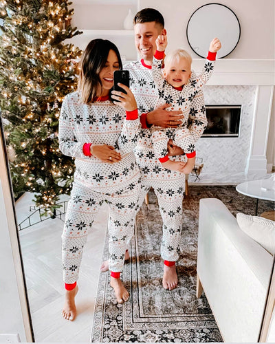 Family of six wearing matching white and red Christmas pajamas with snowflake and fair isle patterns. - Image 3