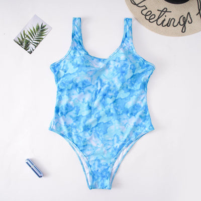 Purple tie-dye one-piece swimsuit with a scoop neck, worn by a person in a poolside setting. - Image 13
