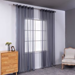 Sheer pink rod pocket curtain hanging on a black curtain rod, offering light transmission for a modern room. - Image 11