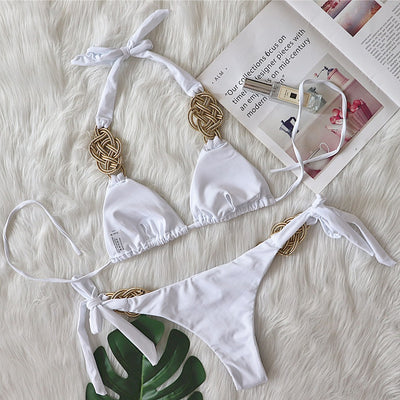 White two-piece bikini with gold braided knot details on the halter straps and tie-side bottom, laid flat. - Image 15