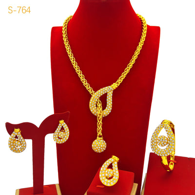 Gold-plated four-piece jewelry set with teardrop rhinestone necklace, bracelet, earrings, and ring on red velvet stands. - Image 2