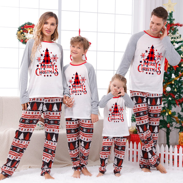 Family of four wearing matching Christmas pajamas with 'MERRY Christmas' text, leopard print, and plaid trees.