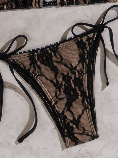 Black lace triangle-cup tie-front bikini swimsuit with nude lining, shown flat on a light marble surface. - Image 17