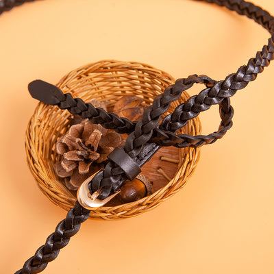 Women's braided brown leather belt with a D-shaped gold-tone pin buckle, coiled on a peach background. - Image 4