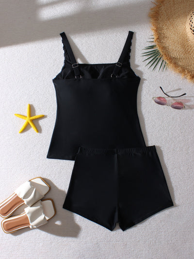 Women's black and leopard print tankini swimsuit with ruched top and swim shorts, modeled on a beach. - Image 11