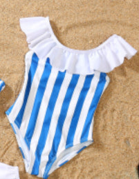 Blue and white striped one-piece swimsuit with a bow detail on the bust, laid on sand with sunglasses. - Image 8