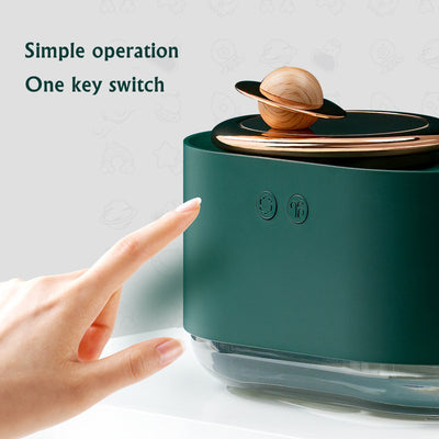 White USB rechargeable mini humidifier with a rose gold top accent and a wooden planet decoration. - Image 9