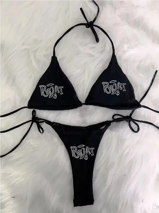 Black halter bikini with rhinestone 'BRAT' lettering on triangle top and tie-side bottom, displayed on white faux fur. - Image 5