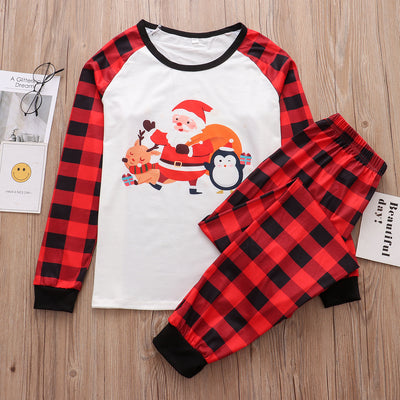 Christmas pajama set with a white long-sleeve top featuring Santa, reindeer, and penguin, and red and black plaid pants.