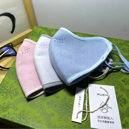 Dark gray cotton head-mounted mask with adjustable ear loops, shown in packaging on a patterned green surface. - Image 14